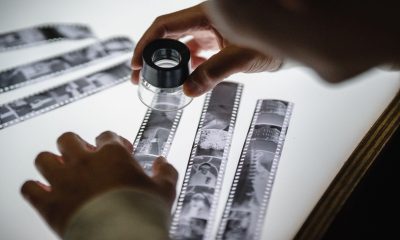 A person looking at some undeveloped film using a magnifier